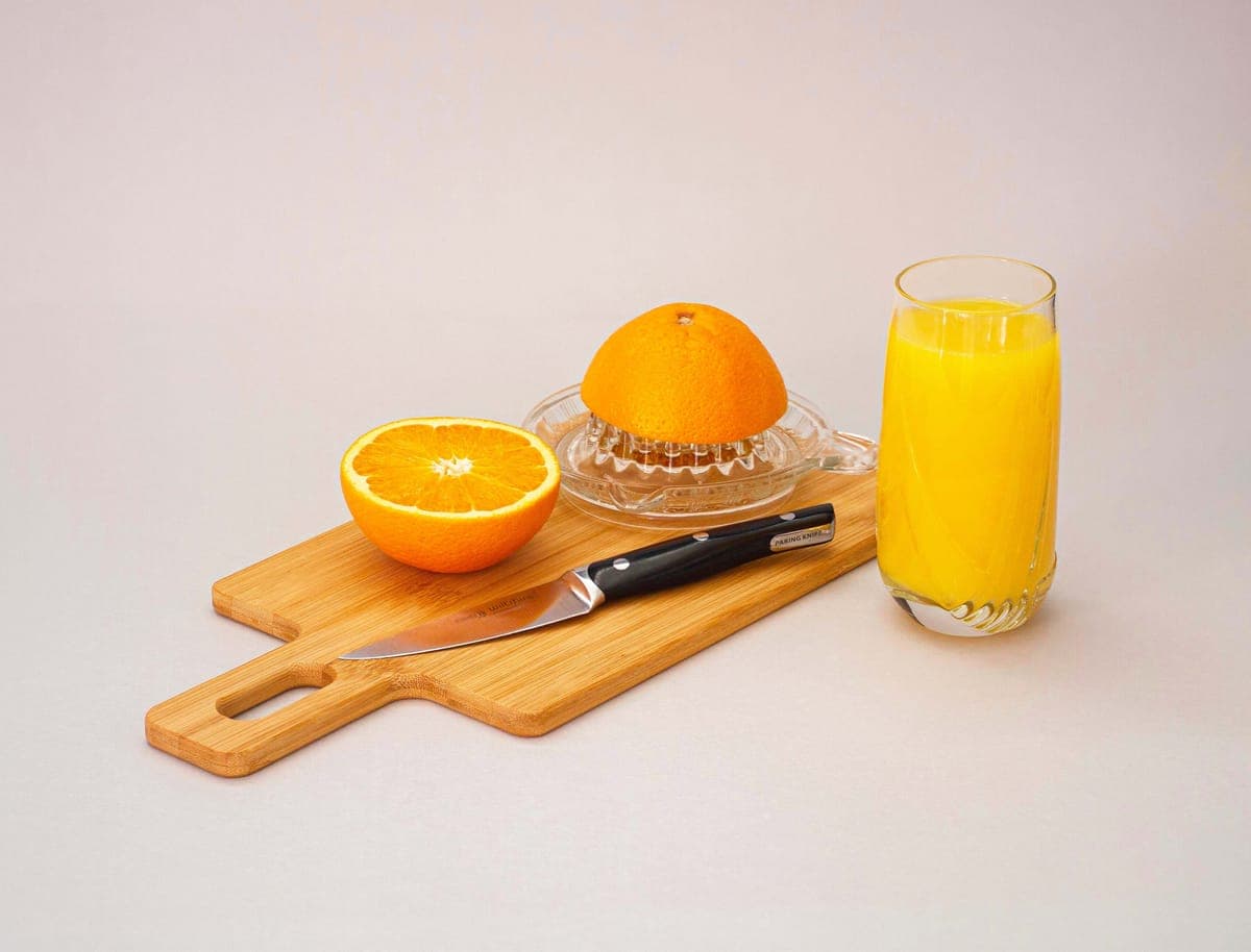 An electric citrus juicer with halved oranges