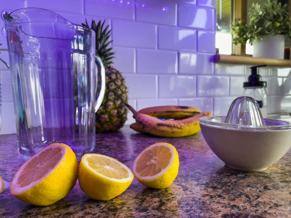 A handheld citrus squeezer with a cut lemon