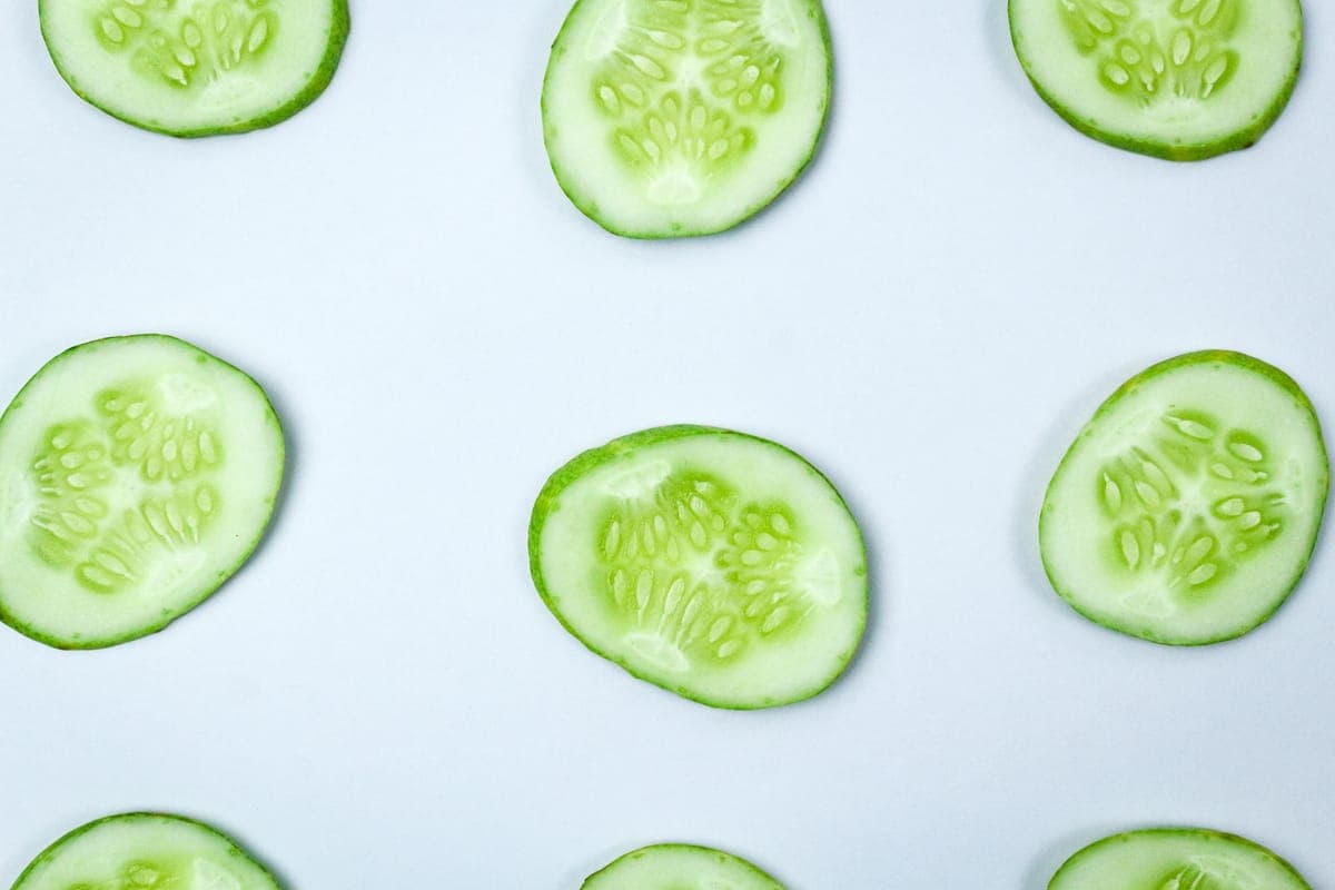 Fresh cucumber slices on a pale surface