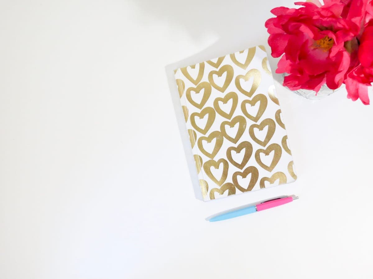 A notebook and pen on a bright minimal desk