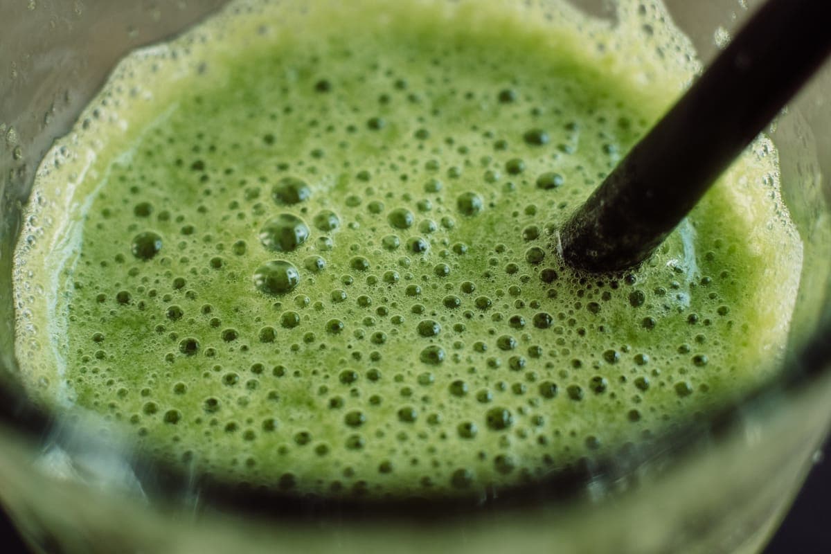 A glass of juice with foam and bubbles
