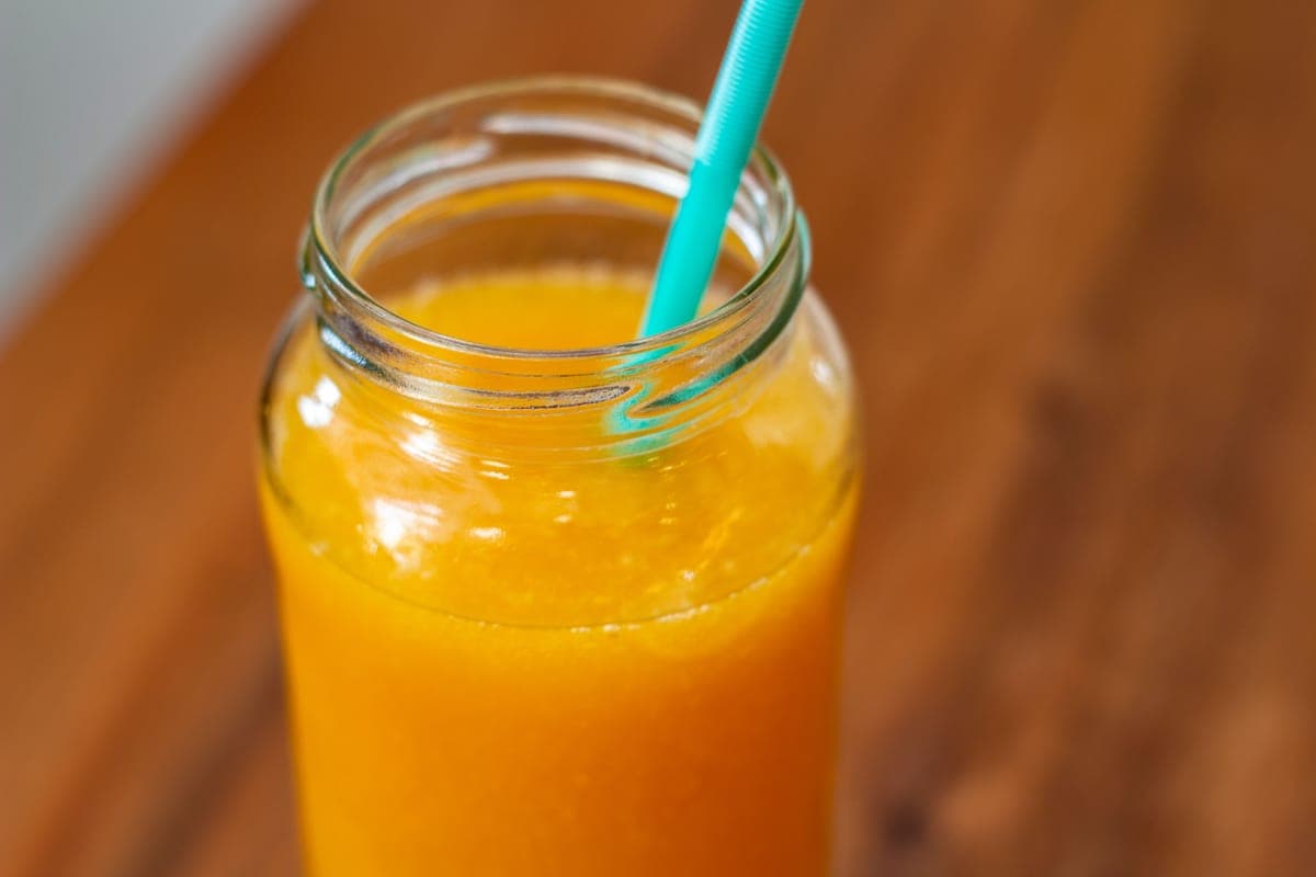 Mason jars of juice in a refrigerator