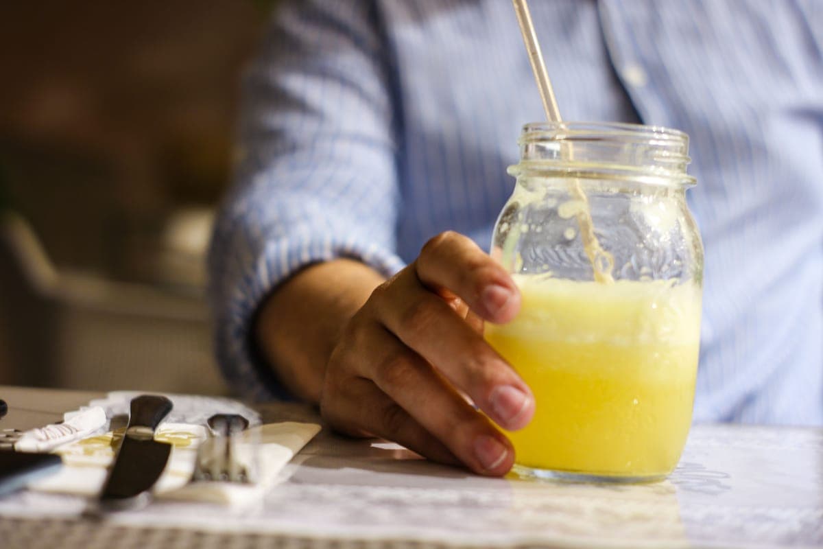 Hands holding a glass of juice in warm light