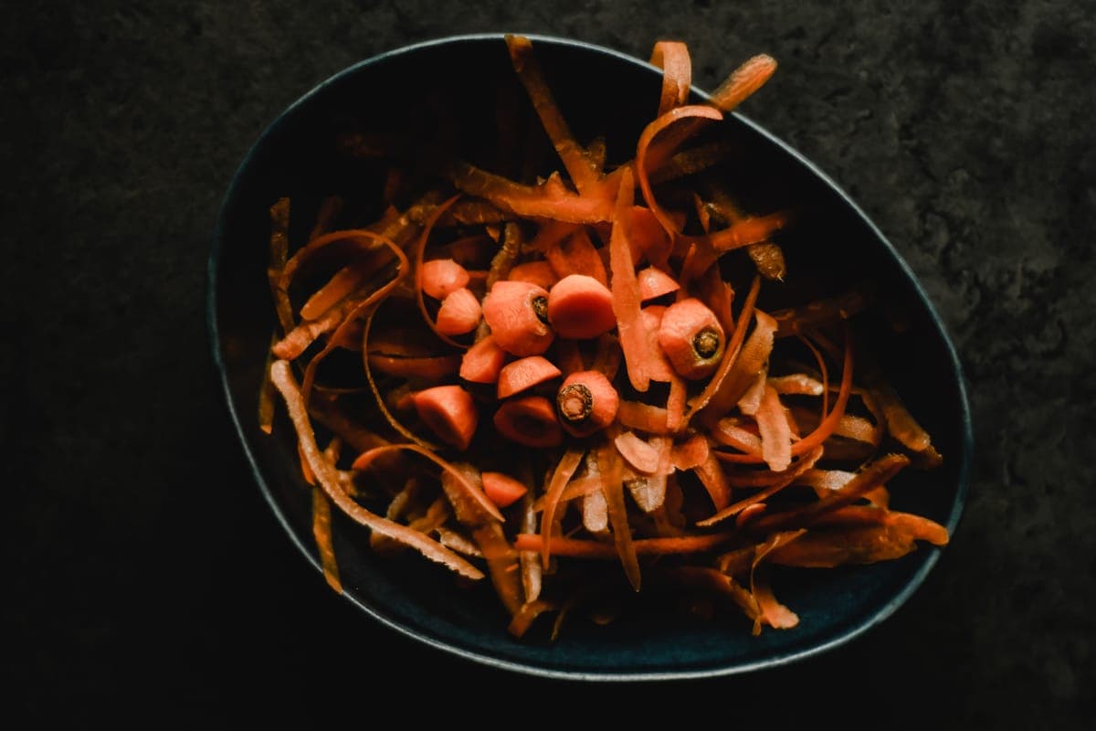Vegetable pulp in a bowl beside kitchen scraps